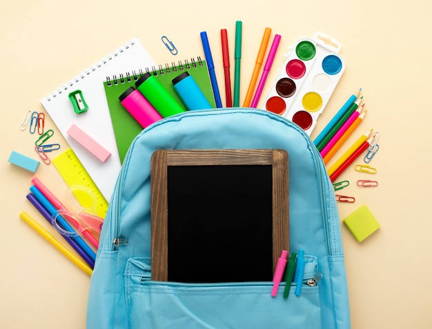 Top view of back to school stationery with blackboard and backpack