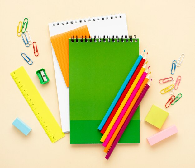 Top view of back to school stationery with notebooks and colored pencils