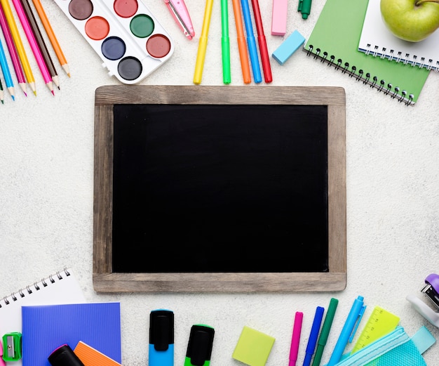 Top view of back to school supplies with blackboard and colorful pencils