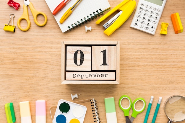 Foto gratuita vista dall'alto di ritorno a materiale scolastico con calendario e matite