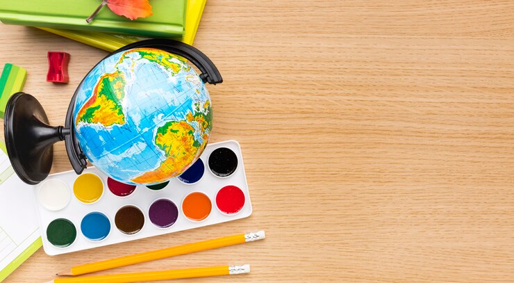 मुफ़्त फोटो top view of back to school supplies with globe and copy space