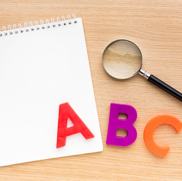 Top view of back to school supplies with notebook and letters