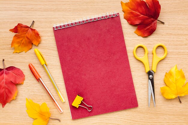 Top view of back to school supplies with notebook and scissors