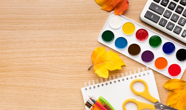 Top view of back to school supplies with notebook and watercolor