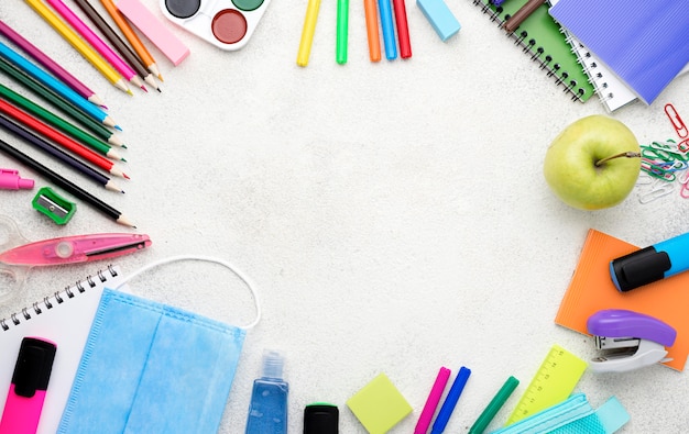 Top view of back to school supplies with pencils and apple