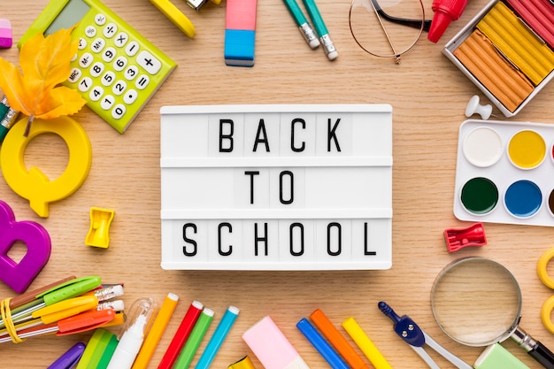 Top view of back to school supplies with pencils and light box