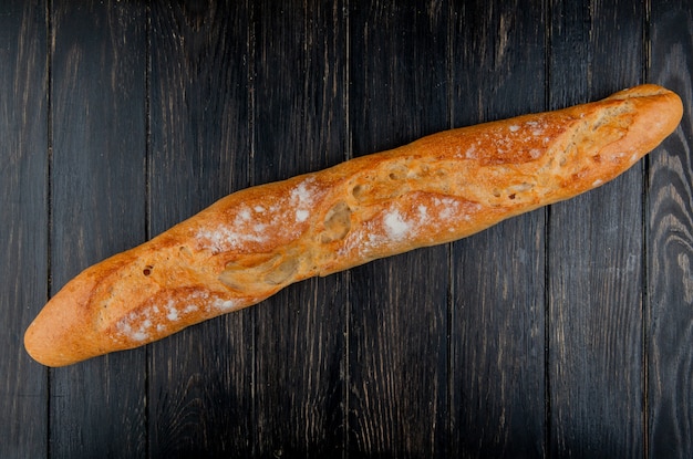 Top view of baguette on wooden background