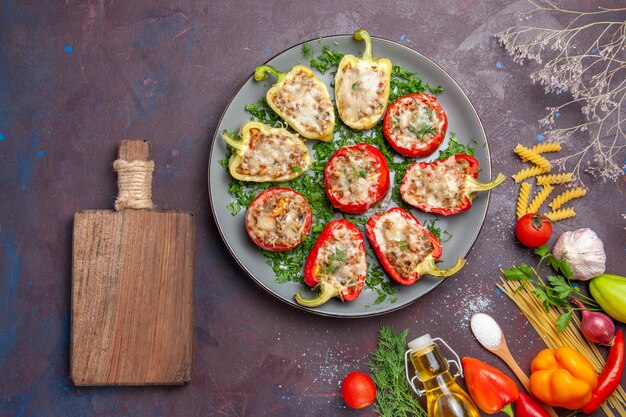 Top view baked bell-peppers delicious meal with meat inside and greens on dark background meal dinner dish food bake