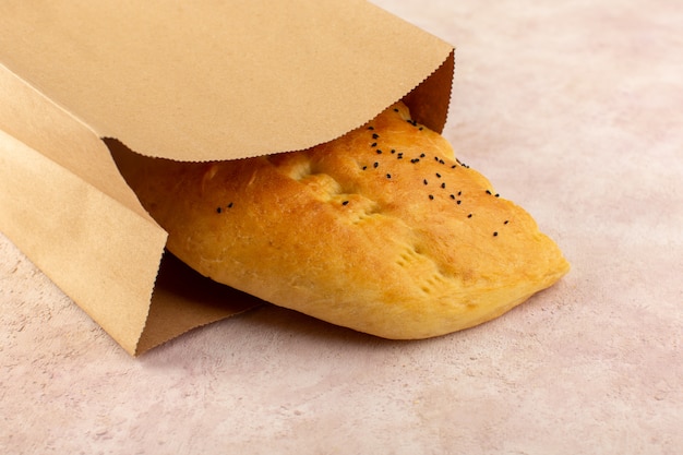 A top view baked bread hot tasty fresh half sliced inside paper packages on pink