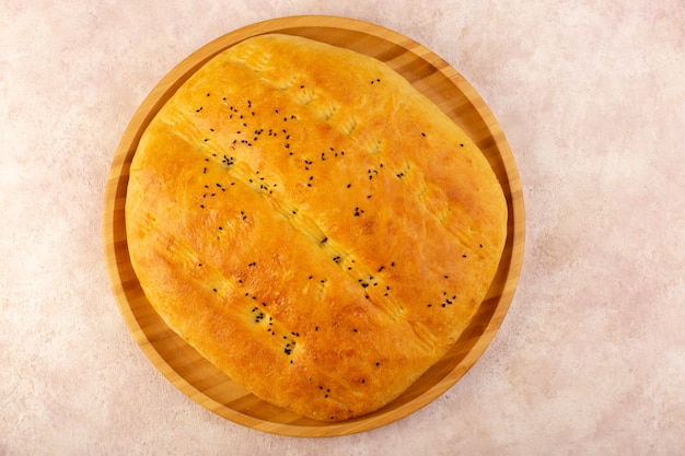 Вид сверху испеченный хлеб горячий вкусный свежий внутри круглого стола на розовом