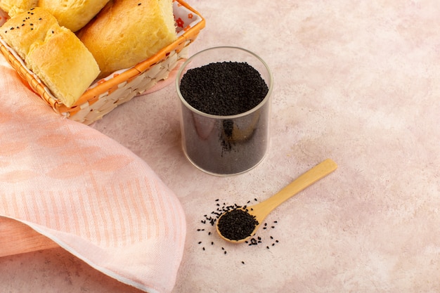 A top view baked bread hot tasty fresh sliced inside bread bin along with pepper on pink