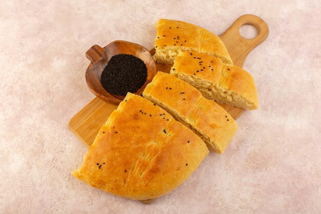 A top view baked bread hot tasty fresh sliced on wooden desk on pink