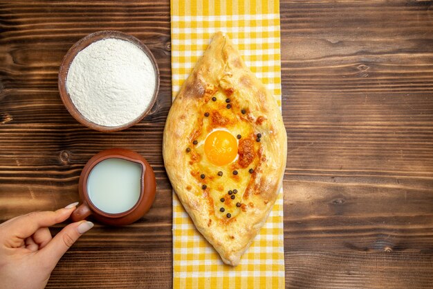 Foto gratuita vista dall'alto pane cotto con latte d'uovo cotto e farina sul pasto della colazione del panino della pasticceria del pane della tavola