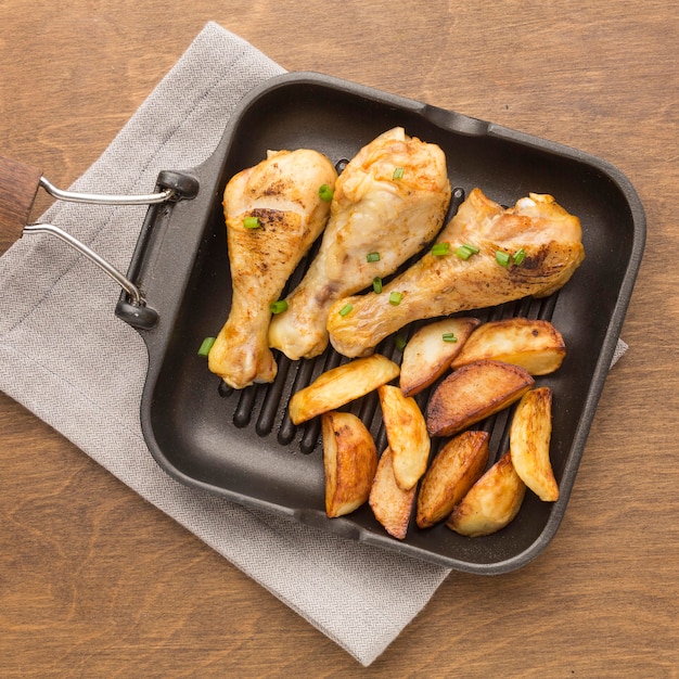 Бесплатное фото Вид сверху запеченный цыпленок и дольки на сковороде