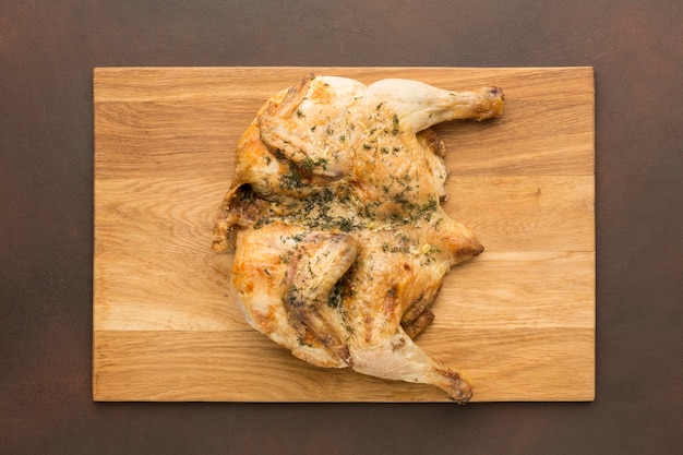 Top view baked chicken on cutting board