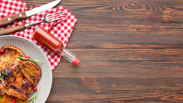 Vista dall'alto di pollo al forno e fette d'arancia sul piatto con salsa e copia-spazio