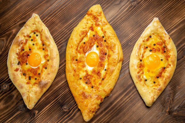 top view baked egg breads fresh off the oven on brown desk dough egg bread bun breakfast