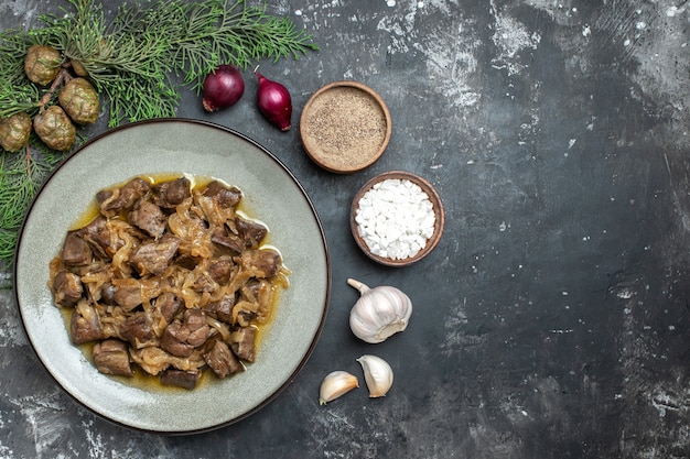 Free photo top view baked liver and onion on plate pine tree branch salt and pepper garlic