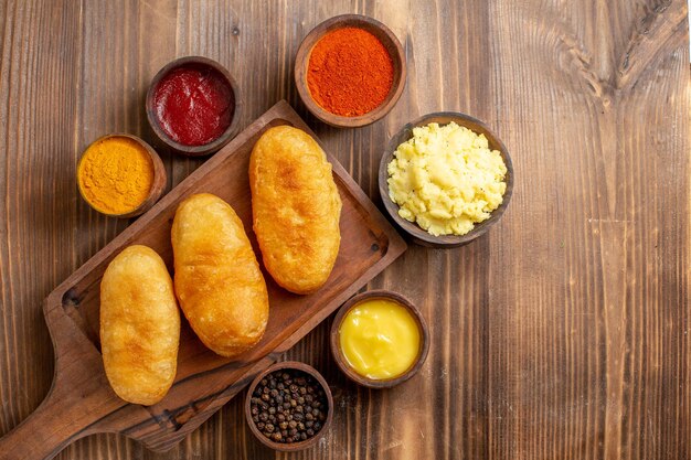 Top view baked potato hotcakes with seasonings on brown wooden desk cake bake dough oven potato meal