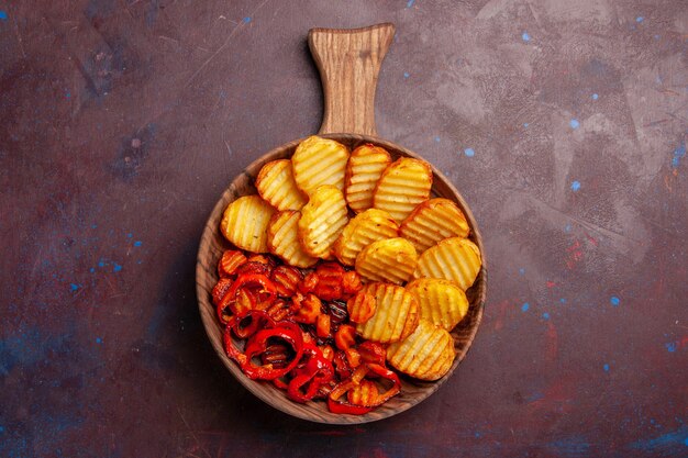 Top view baked potatoes with cooked vegetables inside plate on the dark space