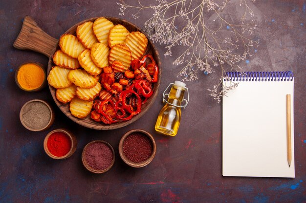 Top view baked potatoes with different seasonings on dark desk