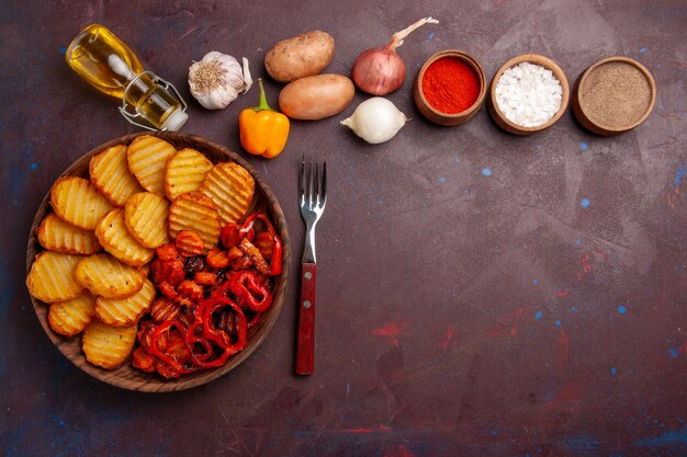 Top view baked potatoes with different seasonings on dark space