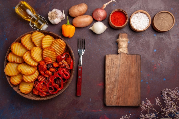 Top view baked potatoes with different seasonings on the dark space