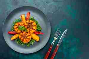 Free photo top view baked potatoes with minced meat and greens inside plate on the dark blue desk.