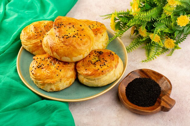 焼きたての丸い形の丸い形のおいしいホット新鮮な花と緑のプレートの中のオーブン