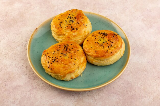 A top view baked qogals round shaped tasty hot fresh off the oven inside green plate