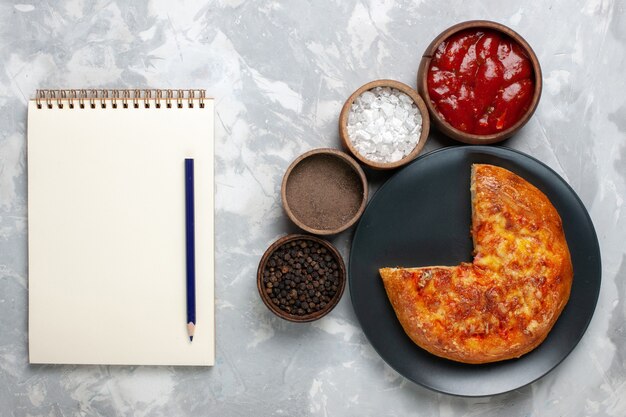 Top view baked sliced pizza with seasonings on white