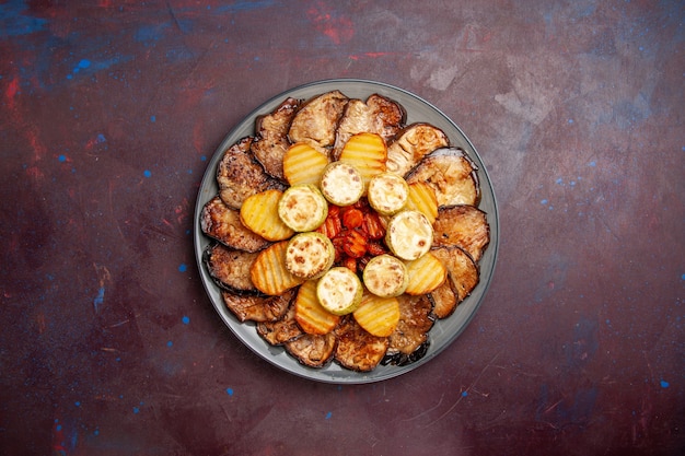 Foto gratuita vista dall'alto verdure al forno patate e melanzane all'interno del piatto su uno spazio buio