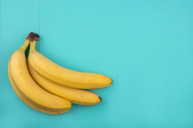 Top view of bananas on a turquoise surface