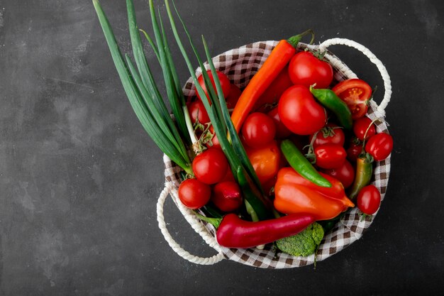 Free photo top view of basket full of vegetables on black surface