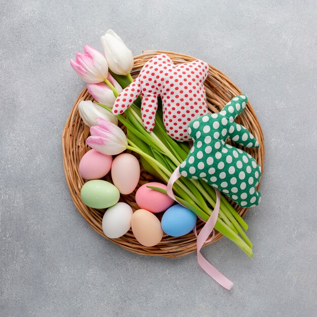 Top view of basket with easter eggs and tulips