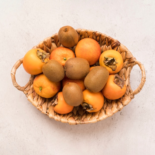 Foto gratuita cesto vista dall'alto con frutti esotici sul tavolo