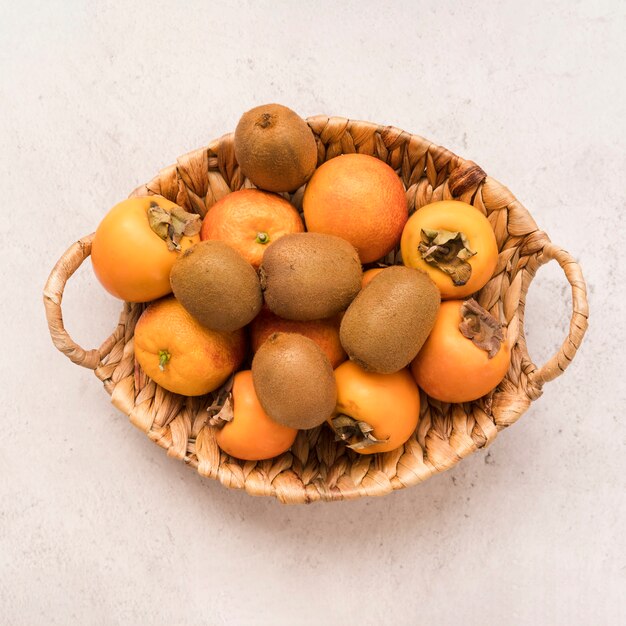 Top view basket with exotic fruits on the table