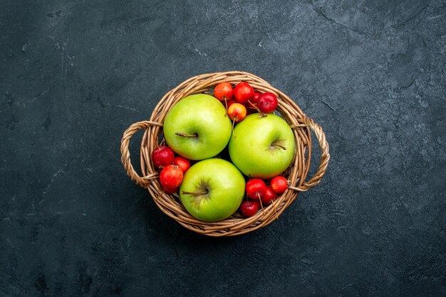 Корзина с фруктами, яблоками и черешней на темной поверхности, фруктовая композиция, ягодная композиция, свежесть, вид сверху