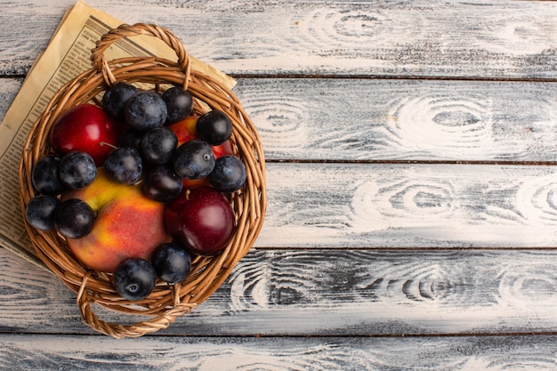 Free photo top view of basket with fruits on the grey wooden des