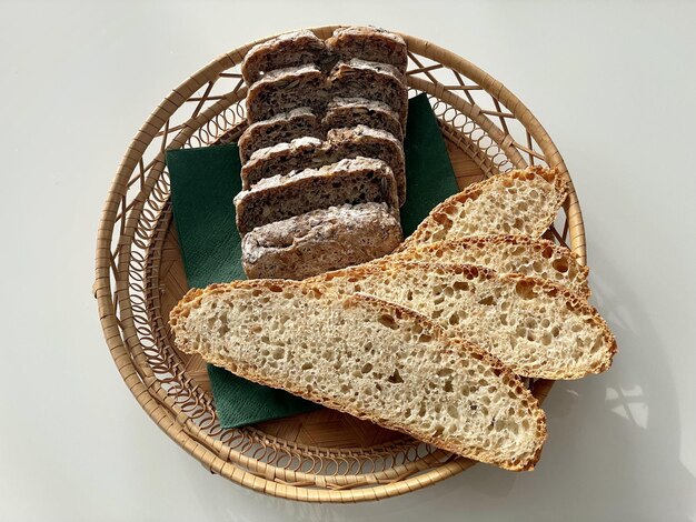 Top view of a basket with two types of bread on the white table