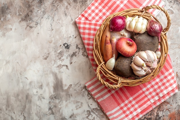 Top view basket with vegetables garlics onions and beet on light photo ripe salad diet color free space for text