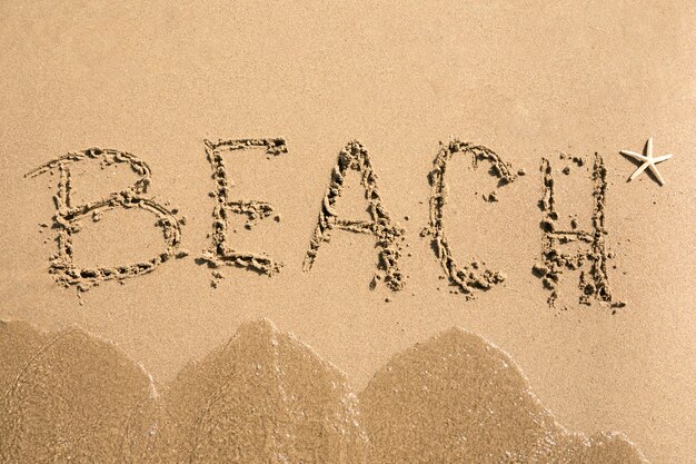 Top view beach written on sand