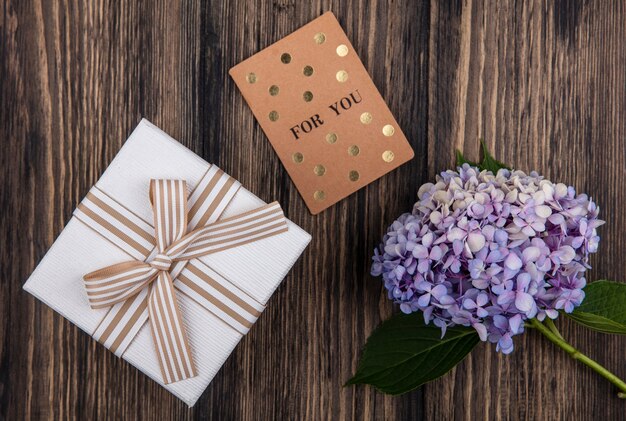 Top view of beautiful gardenzia flower with leaves with gift box on a wooden background