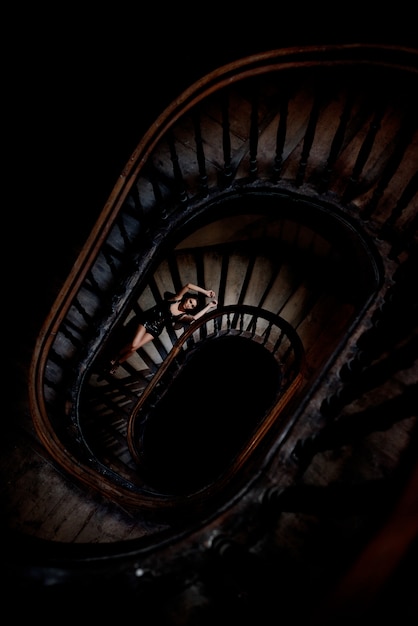 거의 벌거 벗은 어두운 둥근 계단에 누워있는 아름다운 소녀의 평면도
