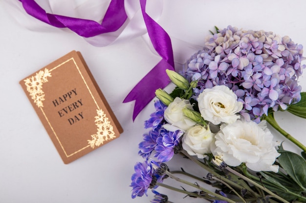 Top view of beautiful and lovely flowers like roses daisy flowers with card on a white background