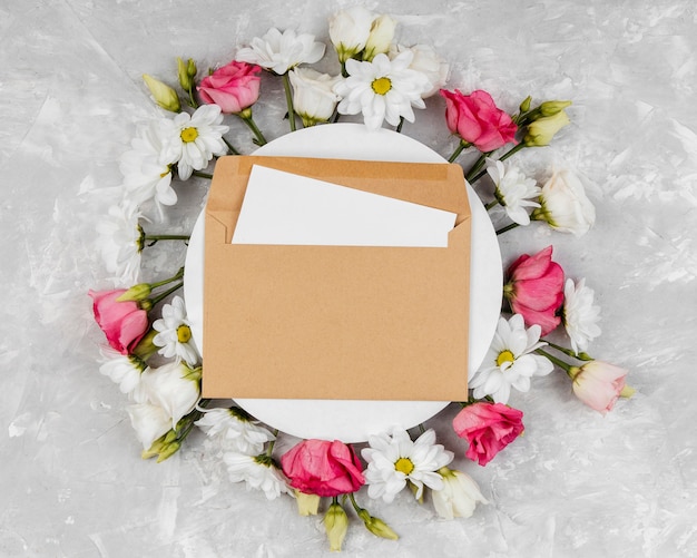 Top view beautiful spring flowers composition with round card and envelope