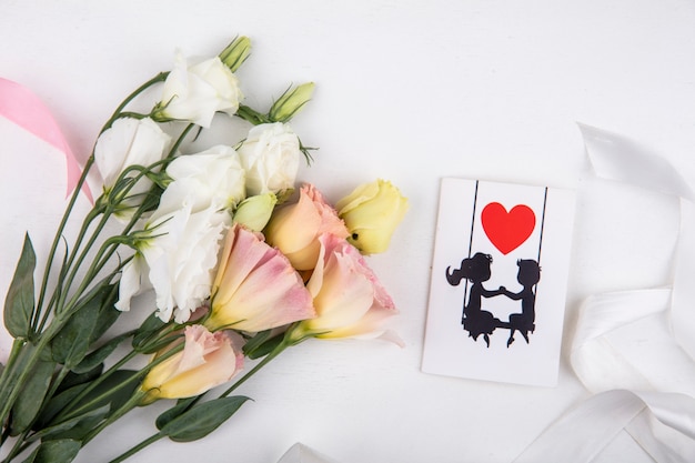 Free photo top view of beautiful white roses with love card on a white background