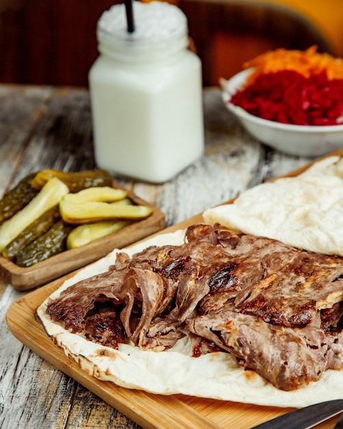 Top view of beef doner slices placed between flatbread