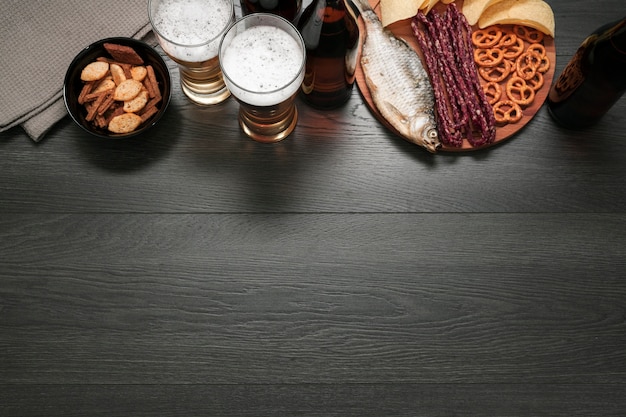 Top view beer glass and bottle with food platter with copy space