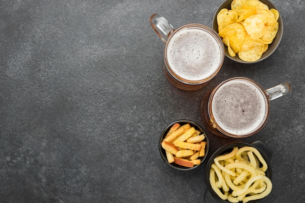 Free photo top view beer and snacks on stucco background